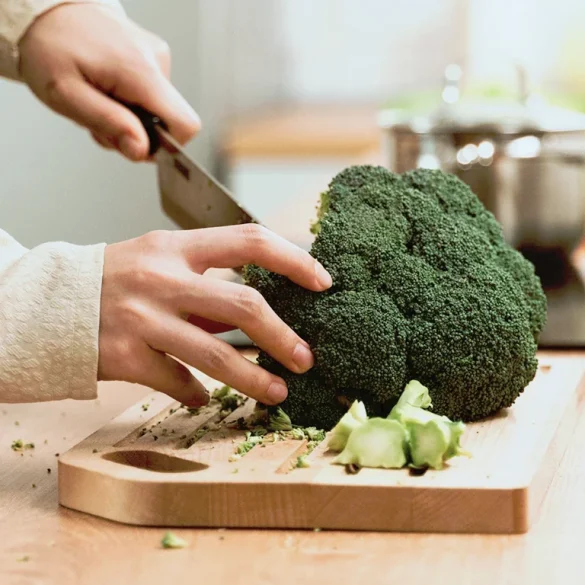 Close-up of a knife chopping raw broccoli